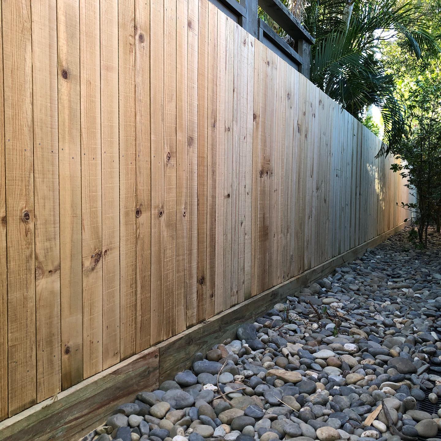 Timber Paling Fence: New hardwood paling fence with a pebble drainage strip.